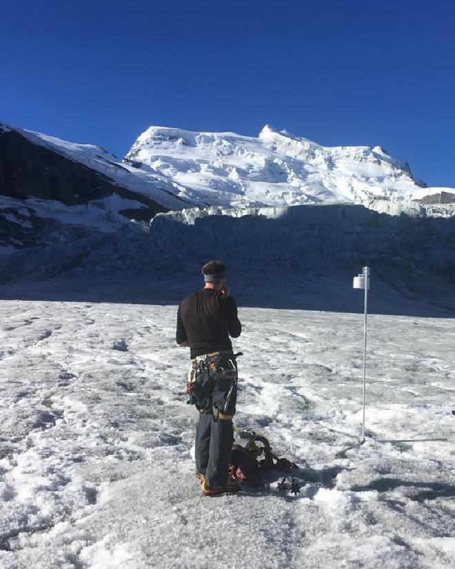 Instalación de una estación en el glaciar de Corbassière, Alpes suizos. El investigador de ISTA Thomas Shaw mira hacia arriba hacia el Grand Combin. Crédito de la imagen: © Pascal Buri