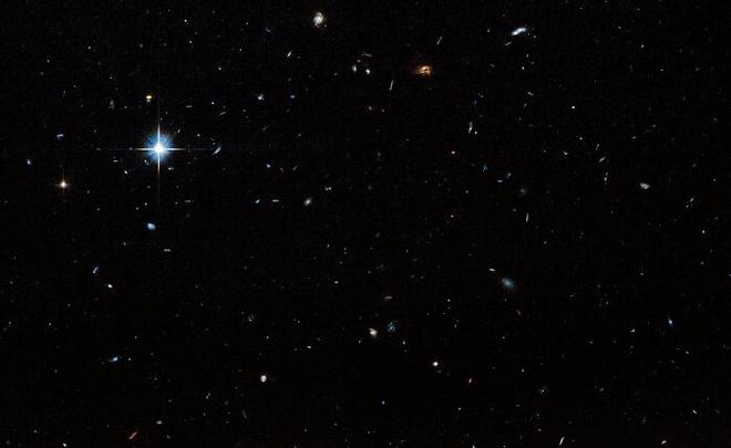Esta imagen muestra el campo en blanco de la región circundante de Nube-9, que se encuentra a 2.000 años luz de la Tierra. Un campo oscuro con estrellas y galaxias de diversos tamaños salpica la imagen. Una estrella particularmente brillante es visible en la parte superior izquierda de la imagen. Crédito de la imagen: NASA, ESA. G. Anand (STScI), y A. Benitez-Llambay (Univ. of Milan-Bicocca); Procesamiento de la imagen: J. DePasquale (STScI)